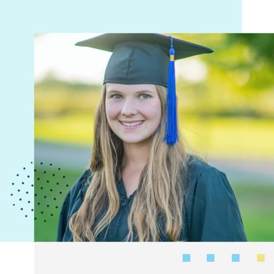 Estudiante de posgrado sonriendo y con un sombrero de graduación